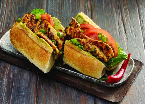 Sandwich au poulet grillé po'boy et sauce épicée à l'avocat et à la moutarde de Edition Nouvelles | Photo de Edition nouvelles